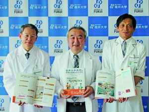 記者発表をする腰地病院長ら（中央）