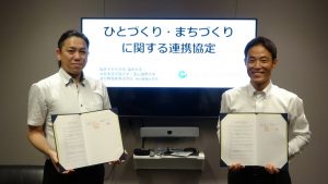 協定書を手にする木村優研究科長（左）と地域創生Coデザイン研究所の東山真也取締役（右）