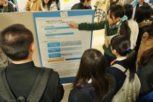 大学生のポスター発表を聞く高校生