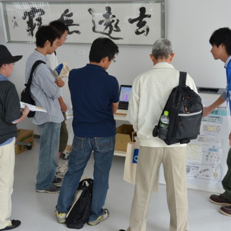 学生の説明に熱心に耳を傾ける参加者