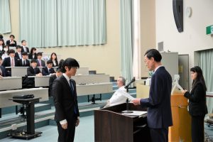内木医学部長から認定証を受ける学生代表の三田英貴さん