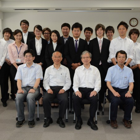 「工学研究科長と担当教職員および修了生による集合写真」