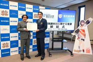 締結した覚書を手に並ぶ、岸教授と福井県警察生活安全部長北道貞邦氏