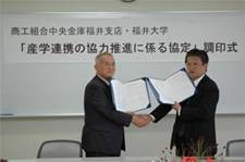 調印後、固く握手する背戸支店長と児嶋学長